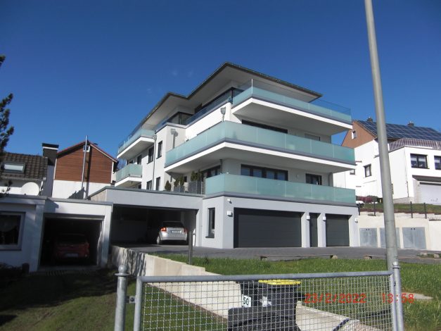 Fertiggestelltes Mehrfamilienhaus mit Balkonen und Tiefgaragenzufahrt